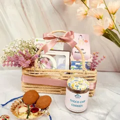 A beautiful jute basket hamper curated specially for sisters. It's filled with skincare goodies, cookies, and a rakhi thali, making it a thoughtful and pampering gift.