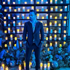 Dressed to impress in a dark suit against a backdrop of candles. This look is ideal for a formal, elegant evening event.
