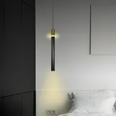 A single black and gold pendant light can be a simple yet effective lighting solution for a bedside. It provides focused downward light for reading and adds a touch of modern elegance.