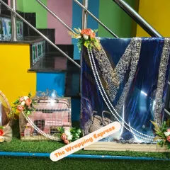 Another view of the wedding trousseau packing. The suit is draped and decorated with pearl strings and flowers, making it a stunning display piece.