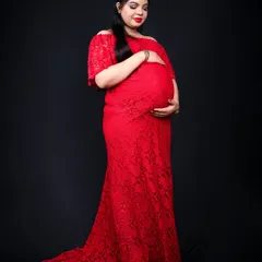 A beautiful full length solo maternity portrait. The elegant red lace gown against the dark backdrop creates a powerful and timeless image celebrating motherhood.