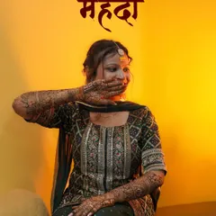 A creative portrait from a Mehendi function. The warm, golden light complements the bride's joy and the rich color of the henna. This kind of shot adds an artistic touch to the wedding album, celebrating the tradition in a modern way.