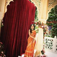 A beautiful shot of my client wearing a vibrant orange tiered saree by Arpita Mehta, perfect for a daytime wedding event.