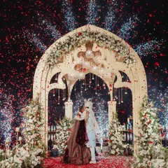 A moment of pure magic as the couple exchanges vows under a shower of fireworks and rose petals. We designed this Varmaala ceremony on a custom-built platform over the serene lagoon at Zuri Kumarakom, creating a dramatic, cinematic experience against the night sky.