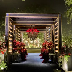 For this cocktail night, we created a dramatic tunnel-like entrance. Lined with walls of candles and overflowing red florals under a striking red chandelier, it guided guests from the natural greenery outside into a glamorous, European-inspired dreamscape.