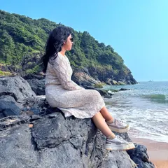 A trekker sits on the rocks, gazing out at the serene ocean during our Gokarna beach trek.