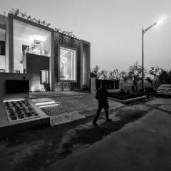 Another perspective of the "House of Frames" villa, showcasing how the structure commands its site. The design thoughtfully integrates landscaping and exterior lighting to create a welcoming yet impressive modern home.