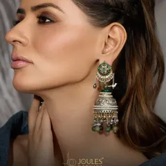 An heirloom of elegance, these oxidized silver jhumkas feature a delicate bird motif and green bead drops, embodying folk elegance.