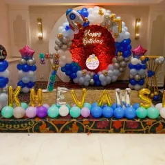 A wider view of our outer space themed party, showing the name "Khevansh" in foil balloons. We can customize the setup with the birthday child's name and age.