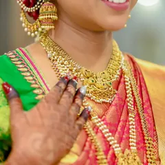 A closer look at the details of our temple jewellery. You can see the intricate carvings and the beautiful pearl accents on the jhumkas and necklace, designed to complement the rich texture of a Kanjivaram saree.