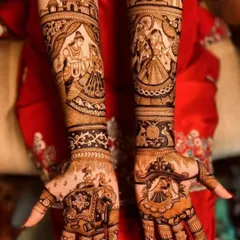 This design tells a complete wedding story, with a varmala scene on one arm and a depiction of the couple on the other, framed by royal elephants and palace architecture.