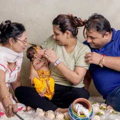 Janmashtami is a celebration for the whole family. Here, parents and a grandparent share a loving moment with their newborn Krishna, creating a cherished multi-generational photograph.