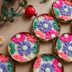 A closer look at the vibrant, multi-colored Daisy Urli candles. Each flower is individually crafted, allowing for unique color combinations that make each wedding favor feel special.
