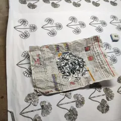 The raw materials for Thikri work: a pile of hand-cut mirrored glass and the paper template that guides the artisan's hand.
