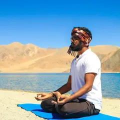Meditating by the serene waters of Pangong Tso in Ladakh. The vastness of the landscape reminds us of our own infinite potential.
