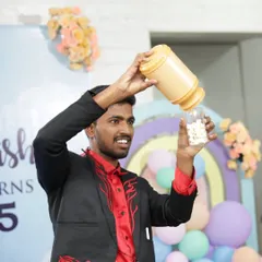 A classic stage magic moment during a birthday celebration. I love performing production illusions like this one, where I make endless popcorn appear from a seemingly empty container.