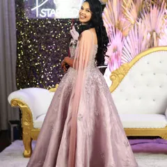 A happy client ready to party in her beautiful lilac gown with a sheer cape at her celebration.