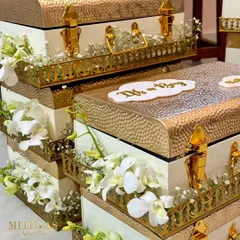 To celebrate the arrival of a baby boy, I designed these elegant white and gold hammered metal trunks. Adorned with fresh white orchids and baby's breath, they serve as a beautiful keepsake for the new parents.