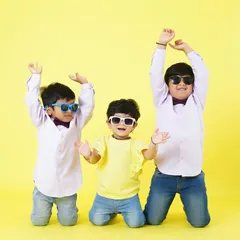 Three brothers having fun and dancing in the studio, wearing sunglasses and big smiles. A perfect snapshot of their playful bond.