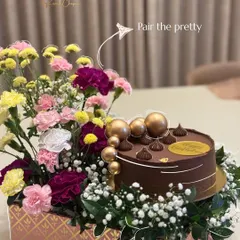 I love pairing the pretty with the delicious. This birthday arrangement combines a decadent, 100% eggless chocolate cake with a vibrant bouquet of fresh carnations and baby's breath, creating a complete celebration in a box.