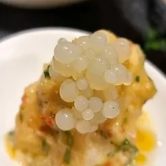 A close-up of our bird's eye chili and kaffir lime prawns, topped with lemon caviar. This dish is a perfect balance of spicy, tangy, and fresh, showcasing the bold flavours of Southeast Asian cuisine.