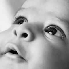 A detailed black and white macro shot capturing the innocence and curiosity in a newborn's eyes. This style of photography emphasizes texture and emotion, creating a powerful and timeless image.