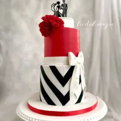 A classic and bold engagement cake in red, white, and black. This design features a sharp chevron pattern and a big white bow, and even includes special slots to hold the couple's engagement rings.