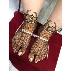 A classic bridal foot design featuring jhumkas and floral patterns. The intricate checkerboard design on the toes adds a beautiful finishing touch.