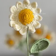 An up-close shot of a single daisy, showing the detail of each of the twelve crocheted petals. I love making these simple and happy flowers.