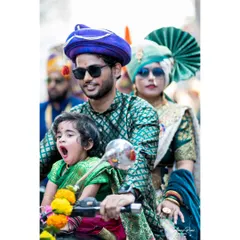 A family enjoying the Gudi Padwa festival together on a motorcycle. The little one's candid yawn adds a touch of real life and humor to this vibrant cultural portrait.
