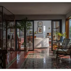 This is my favorite view of the Dhaka home, capturing its heart. The play of light and shadow across the heritage floor tiles, the glimpse into the sunlit living area, and the connection between different zones all speak to a design that is both open and layered.