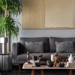 The living room of the Pink Marble House is a curated collection of art, objects, and textures. A pink marble coffee table, grey sofa, and natural wood elements come together to create a sophisticated yet comfortable family space.