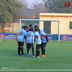 A team huddle before the action begins. I teach my players the importance of unity, strategy, and supporting each other, which are lessons that extend far beyond the football pitch.