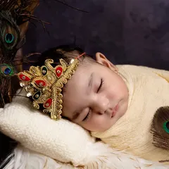 A close-up of our little Krishna, adorned with a beautiful mukut (crown). Every detail, from the peacock feathers to the gentle lighting, is chosen to create a divine and serene portrait.