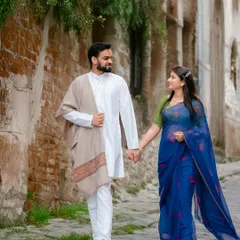 A candid shot of a couple walking hand-in-hand through a rustic city lane. This photo captures a natural, unposed moment that feels authentic and full of story.