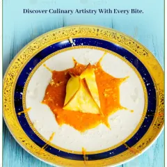 Discover culinary artistry with this elegantly plated appetizer. The delicate pasta parcel is served in a flavourful sauce, presented like a work of art on a fine china plate.