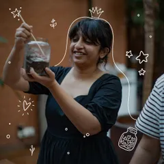 A participant smiles as she carefully arranges the elements inside her glass garden. Our terrarium workshops are a hands-on journey into crafting a miniature world, layer by beautiful layer.