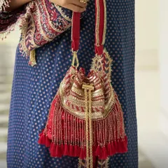 My Emily Red Stylised Handbag is the perfect accessory for traditional red outfits. The combination of red fabric, golden beadwork, and tassels makes it a festive essential for Karwa Chauth or a bridal trousseau.