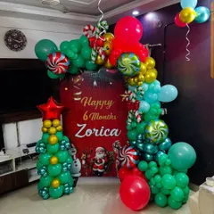 I can combine themes for unique celebrations, like this 6-month birthday that fell during the Christmas season. The setup includes a custom backdrop, a colorful balloon arch, and a small Christmas tree made entirely of balloons.