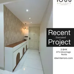 A clean and elegant foyer with a stylish shoe cabinet featuring arched details. The textured wallpaper and pendant light add warmth and character to the entrance.
