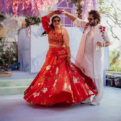 I love the energy of pre-wedding events! For this welcome party, we chose a vibrant red floral lehenga for the bride and a coordinated embroidered jacket for the groom. Their outfits were fun, comfortable for dancing, and perfectly captured the celebratory mood.