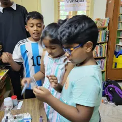 The moment of discovery. A group of kids watch with fascination as the chemical reaction unfolds in the test tube they are holding, learning about biology and chemistry firsthand.