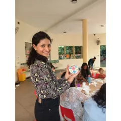 Here I am holding a small, floral Lippan piece, another example of the beautiful art you can create. These workshops are designed to be fun and accessible for everyone, regardless of your artistic background.
