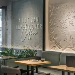 Every detail tells a story. We paired the iconic tagline, "A lot can happen over coffee," with a textured mural honoring coffee's journey, creating a space that is modern yet rooted in the brand's heritage.