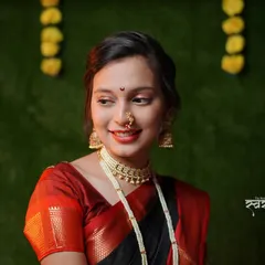 A beautiful portrait capturing the essence of a Maharashtrian festival. The subject's side glance and gentle smile, paired with traditional jewelry like the 'nath' and 'choker', create an elegant look.