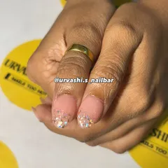 A delicate and dreamy manicure featuring a soft pink base with gold accents. I added personalized initials, a tiny ring charm, and a sprinkle of glitter for a charming and romantic feel.