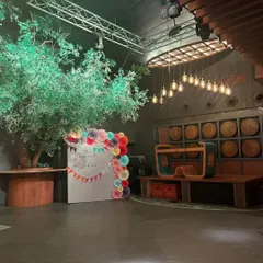 A simple and elegant photo booth for a Lohri celebration. The backdrop is decorated with colorful paper fans and a "Samvid di Lohri" message.