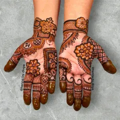 An elegant Indo-western design. This style combines traditional paisley shapes with modern floral art, leaving space on the palm for a light, airy feel.