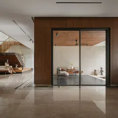 This wide view of Villa Shakthi highlights the open-plan layout and the visual connections between different zones. The polished marble floor reflects light throughout the ground level, enhancing the sense of space and fluidity from the foyer to the living areas.
