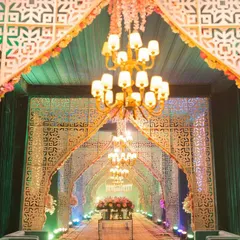 We make a powerful first impression with this grand wedding entrance. A long, dramatic walkway is framed by repeating white geometric arches and illuminated by a series of classic chandeliers, creating a spectacular tunnel of light and elegance for guests to walk through.